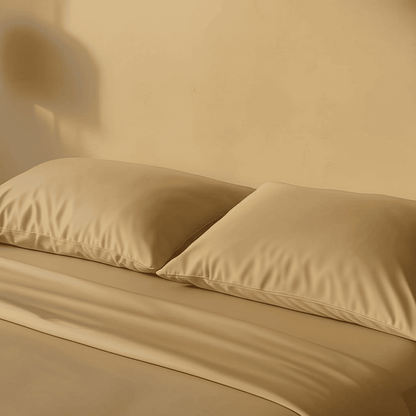 Zwei cremeweiße Kopfkissen mit glatter Bambus-Oberfläche auf einem gemachten Bett.
