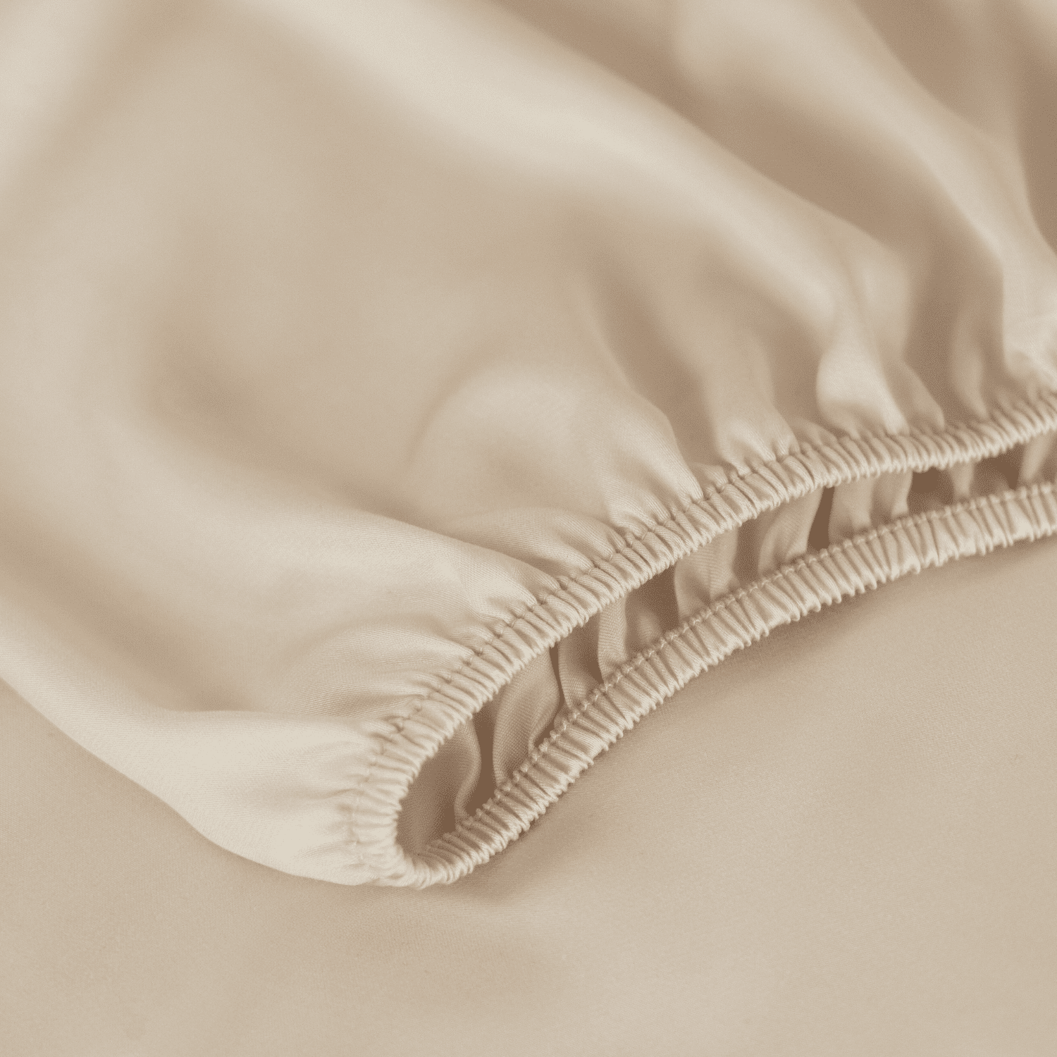 Detailaufnahme eines cremeweißen Spannbettlakens aus Bambus mit elastischem Rand.