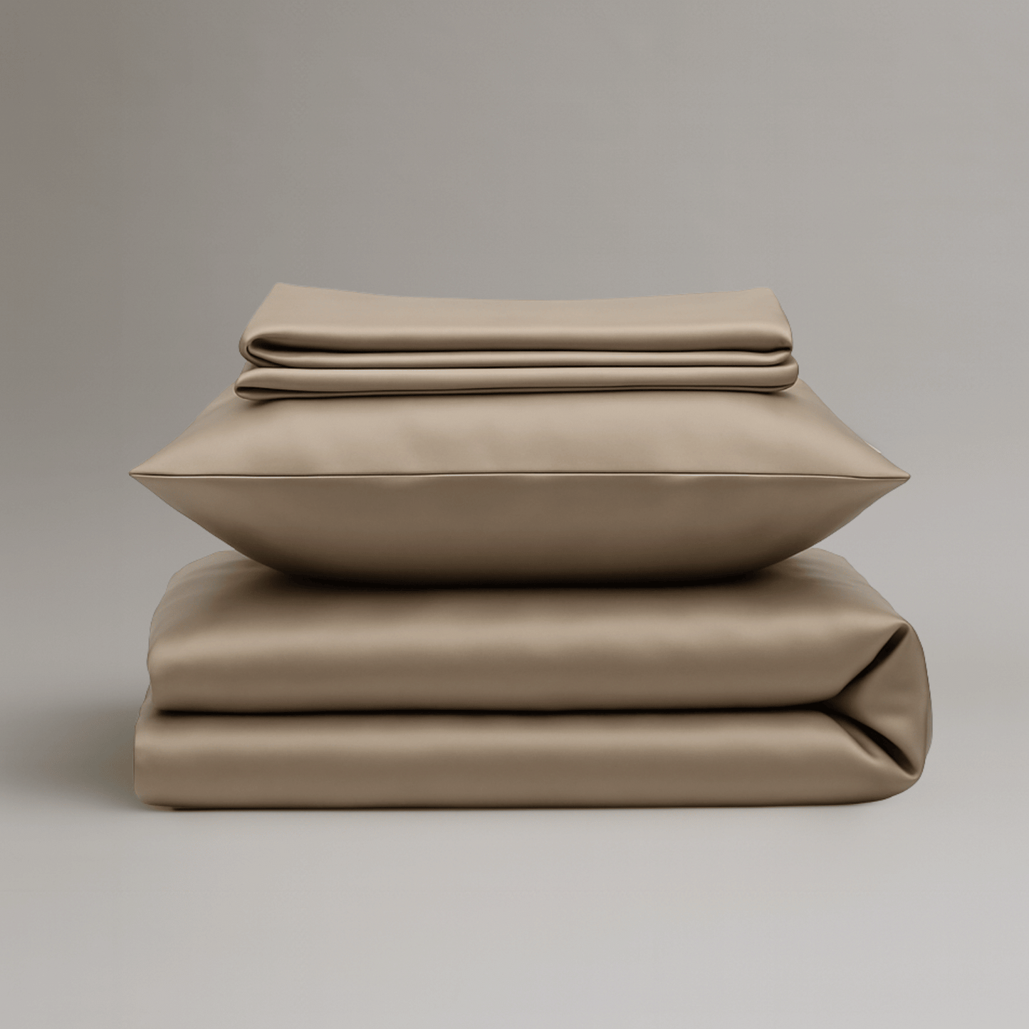 Gefaltetes Bundle aus greigefarbener Bambus Bettwäsche bestehend aus Bettbezug, Kissenbezügen und Spannbettlaken.