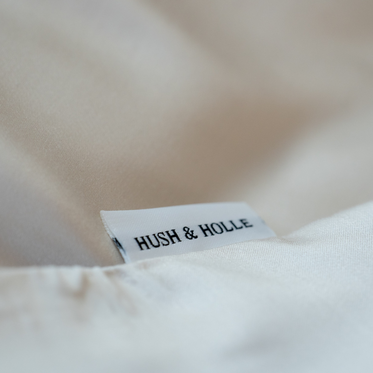 Detailansicht eines Schildes von Hush & Holle in Cremeweiss