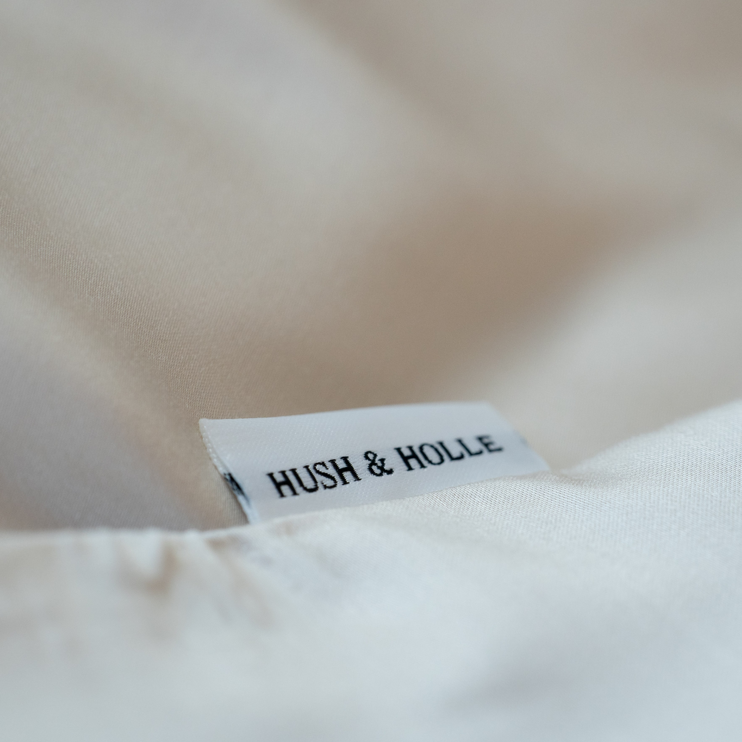 Detailansicht eines Schildes von Hush & Holle in Cremeweiss
